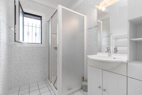 une salle de bain blanche avec un lavabo et une douche dans l'établissement SouthMarina by POM, vue bateaux, terrasse, parking, au Cap d'Agde