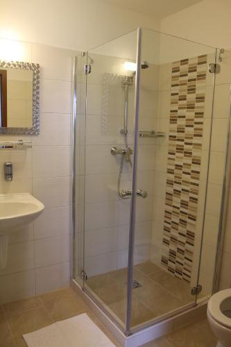 La salle de bains est pourvue d'une douche, d'un lavabo et de toilettes. dans l'établissement Pótkerék Motel, à Győr