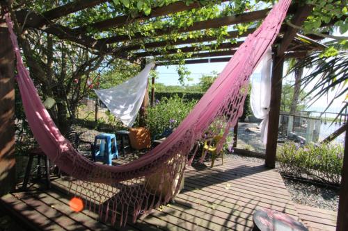 a hammock on a patio with a pergola at Casa Baia da Babitonga in São Francisco do Sul