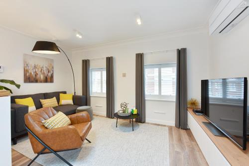 a living room with a couch and a tv at James Street Serviced Apartments by Globe Apartments in London