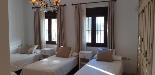 um quarto com duas camas e duas janelas em VILLA LA MARISMA em Chiclana de la Frontera
