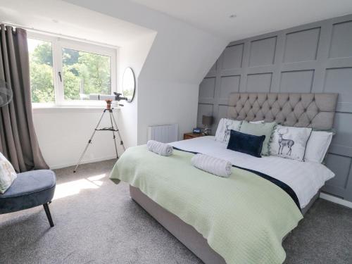 a bedroom with a large bed and a chair at Ben View in Arrochar