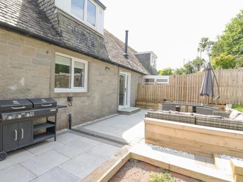 a backyard with a grill and a fence at Ben View in Arrochar