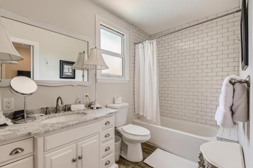 uma casa de banho branca com um lavatório e um WC em Nini's Cottage 4bd 3ba Vacation Rental em West Palm Beach