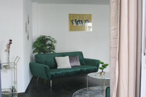 a green couch in a living room with a table at American Ease Apartments - Hahnbach, Vilseck, Weiden in Hahnbach