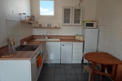 cocina con electrodomésticos blancos y mesa de madera en Charming 48 m apartment in downtown Avignon, en Aviñón