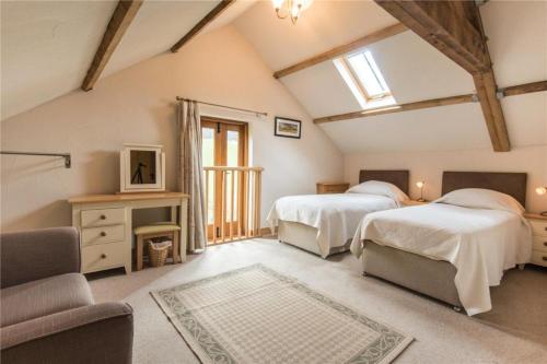 a attic bedroom with two beds and a couch at Baddegai Holiday Cottage in Brecon