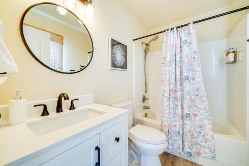 a bathroom with a sink and a toilet and a mirror at Nags Head Vacation Rental with Hot Tub Near Beach! in Nags Head
