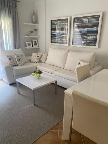 ein Wohnzimmer mit einer weißen Couch und einem Tisch in der Unterkunft Apartamento premium Canela Park in Isla Canela