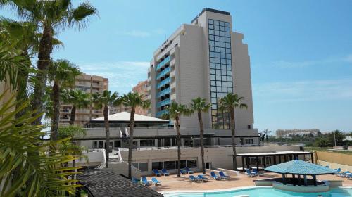 un hôtel avec une piscine et un bâtiment dans l'établissement 4Us LA MANGA VIP HOTEL, à La Manga del Mar Meno