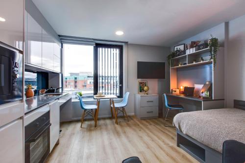 Cet appartement comprend une chambre avec un lit et une cuisine avec une table. dans l'établissement Yugo Explore - Kavanagh Court, à Dublin