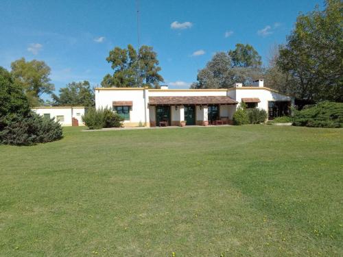 une maison avec une grande cour devant elle dans l'établissement Hospedaje El Rincon, à San Antonio de Areco