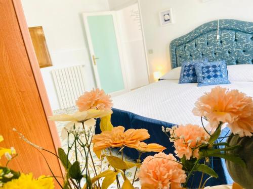 a bedroom with a bed and flowers in the foreground at Casa Colomba in Anacapri