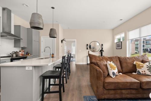 a kitchen and living room with a brown couch and a counter at Mason Lofts at West End in Nashville