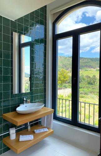 a bathroom with a sink and a large window at Quinta de Fiães in Vilar de Maçada