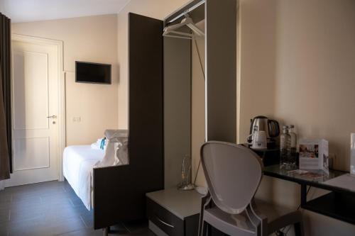 クレモナにあるホテル ドゥオモ クレモナのベッド、デスク、椅子が備わる客室です。