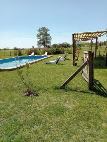 a swimming pool with a wooden fence and a fence at Hospedaje El Rincon in San Antonio de Areco