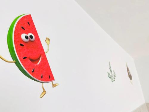 un cocomero con un volto disegnato su un muro di Casa della Frutta ad Anacapri