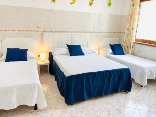 a room with two beds with blue and white sheets at Casa della Frutta in Anacapri