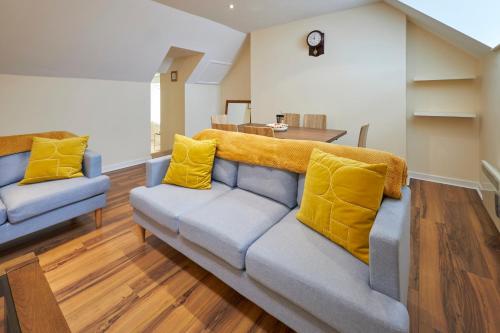 a living room with a couch with yellow pillows at Host & Stay - Scotsgate House in Berwick-Upon-Tweed