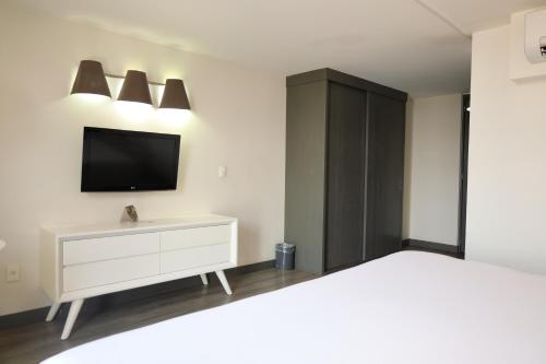 a bedroom with a white dresser and a tv on the wall at Hotel El Ejecutivo by Reforma Avenue in Mexico City