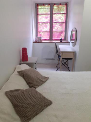 um quarto com uma cama, uma secretária e uma janela em Les chênes blancs em Aubin