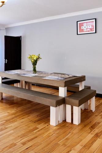 a large wooden table in a room with a vase on it at Airport Royal Guest House in Kempton Park