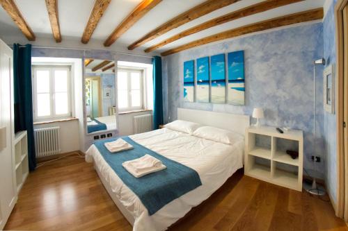 een slaapkamer met een bed met twee handdoeken erop bij Piazza Grande City Residence in Trieste