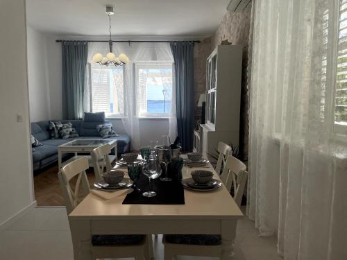 a dining room with a table and a living room at Luxury apartment Lukas in Orebić