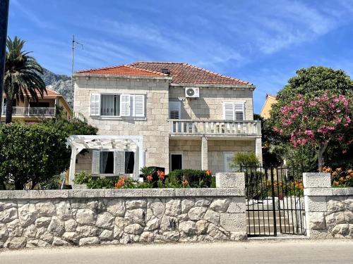 a house behind a stone wall with a fence at Luxury apartment Lukas in Orebić