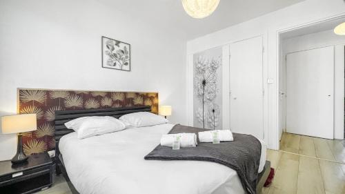 1 dormitorio con 1 cama grande y 2 toallas. en HOMEY Boheme - Proche gare/Proche centre/wifi en Annemasse