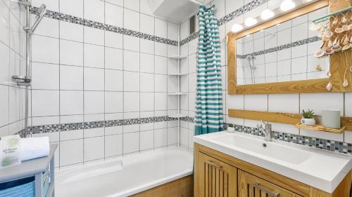 La salle de bains est pourvue d'une baignoire, d'un lavabo et d'une douche. dans l'établissement HOMEY Boheme - Proche gare/Proche centre/wifi, à Annemasse