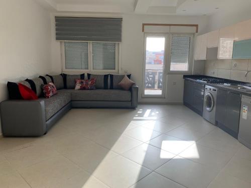 a living room with a couch and a kitchen at La Remaz 35 in El Jadida