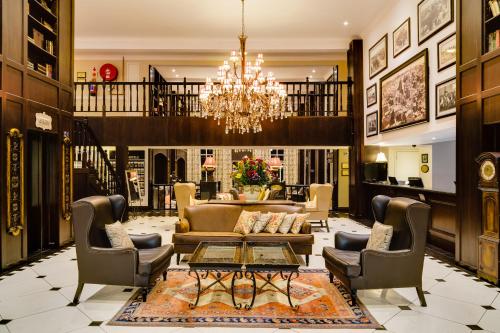 a living room with a couch and chairs and a chandelier at Protea Hotel by Marriott Kimberley in Kimberley