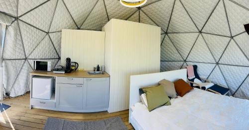 a bedroom with a tent with a bed and a desk at LoveLand Farm Kupolai 