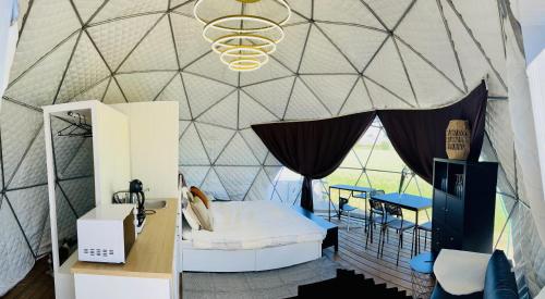 a room with a bed in a tent at LoveLand Farm Kupolai 