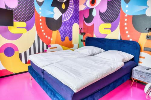 a bed in a room with a colorful wall at Wohnung mit Pool Little King, Little Dagobert in Heimburg