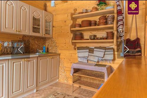 een keuken met houten wanden en een aanrecht met handdoeken bij Райський куточок in Verkhovyna