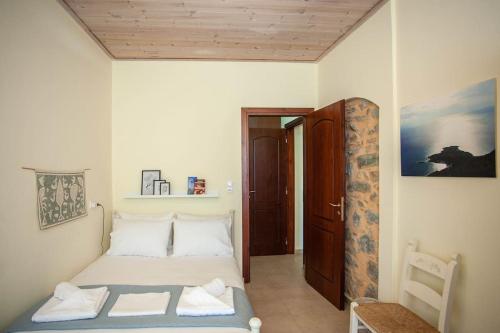 Amphithea Fragokastelo-Skaloti في Skalotí: غرفة نوم صغيرة بسرير وسقف خشبي