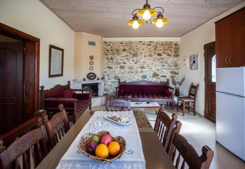 eine Küche und ein Wohnzimmer mit einem Tisch und Obst darauf in der Unterkunft Amphithea Fragokastelo-Skaloti in Skalotí