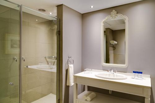 ein Bad mit 2 Waschbecken und einer Dusche in der Unterkunft Protea Hotel by Marriott Kimberley in Kimberley