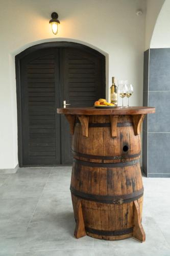 a table on top of a barrel with a bottle of wine at Panoráma Borbirtok in Mencshely
