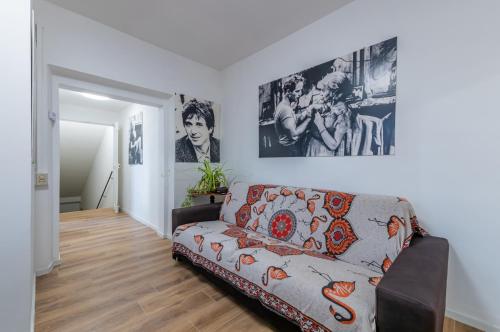a living room with a couch and posters on the wall at GuestHost - Marilyn Apartment tra centro e mare in Pesaro