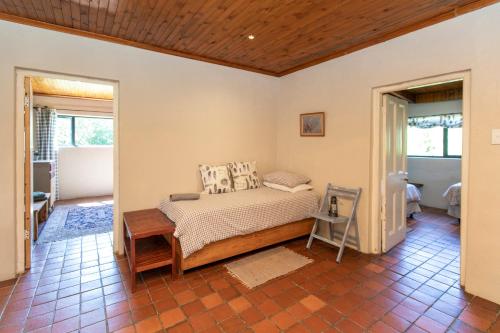ein Schlafzimmer mit einem Bett in einem Zimmer in der Unterkunft Ripon Country Cottage in Himeville