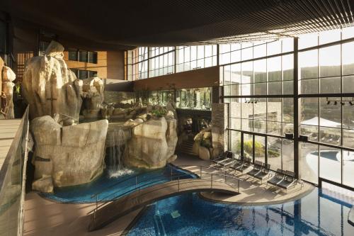 a view of a resort with a pool and a waterfall at H2otel Congress & Medical SPA in Unhais da Serra