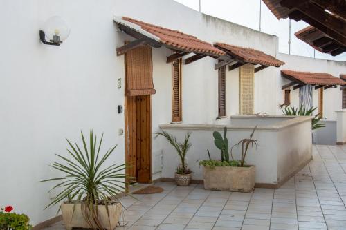 cortile con piante in vaso di fronte a un edificio di Adriatic Suite - Casa vacanze a SantʼAndrea