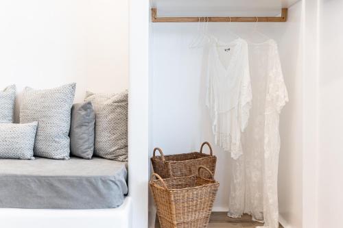 a white room with a bed and a white shirt hanging at Naxos Anamnisi in Plaka