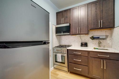 a kitchen with wooden cabinets and a stainless steel refrigerator at Modern Ocean City Getaway Walk to Boardwalk! in Ocean City