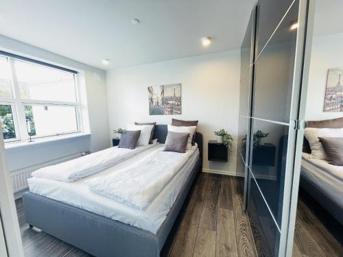 a bedroom with two beds and two windows at aday - Elegant Apartment with Terrace in Svenstrup