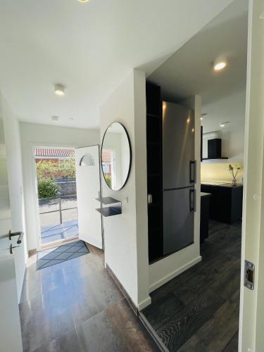 a room with a hallway with a door and a kitchen at aday - Elegant Apartment with Terrace in Svenstrup